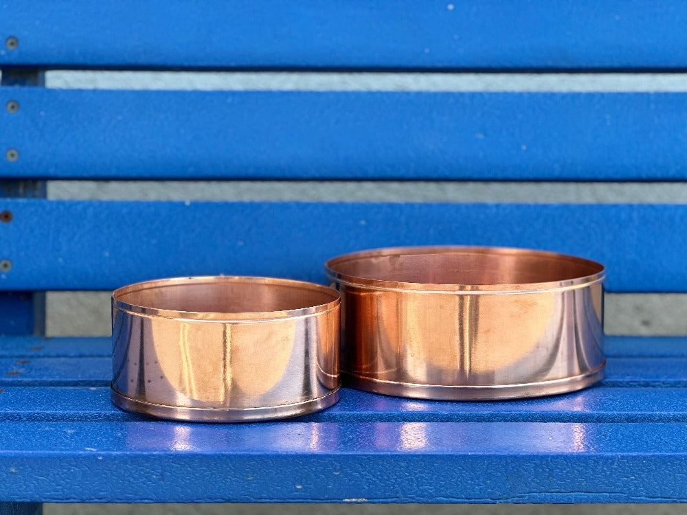 Copper plant pots on blue bench